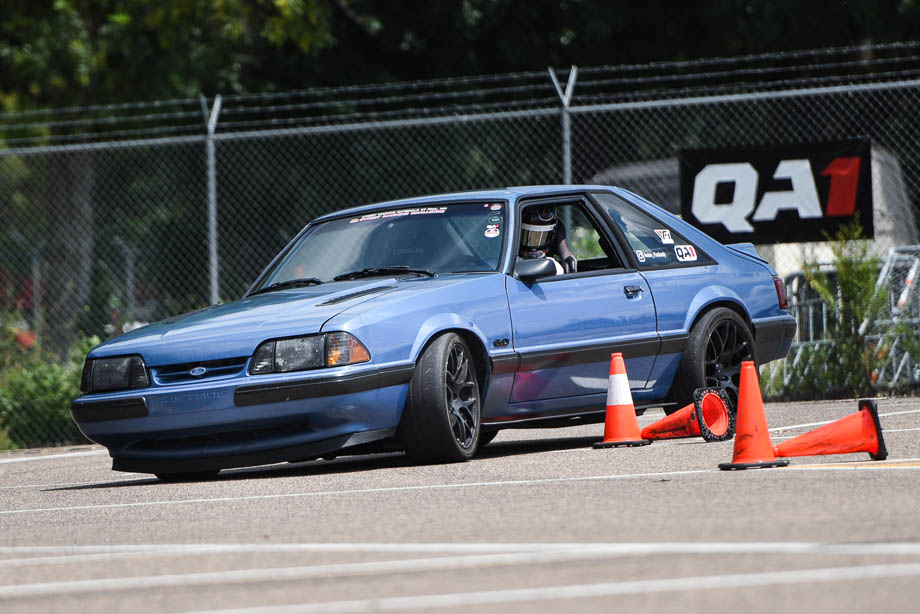 Fox body Mustang on QA1 shocks rounding a corner on the track.