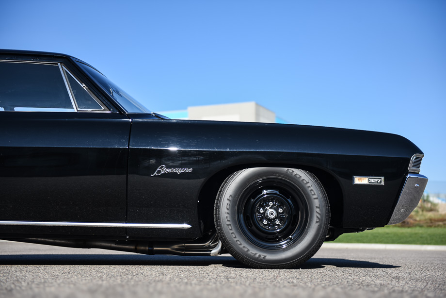 The front wheel of a black 1968 Chevrolet Biscayne.